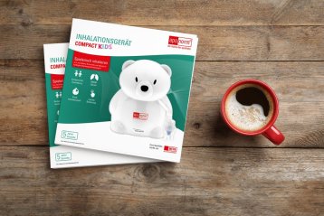 Zwei Broschüren mit dem Inhalationsgerät Compact Kids, neben einem Teddybär als Inhalator und einer roten Tasse mit Kaffee.